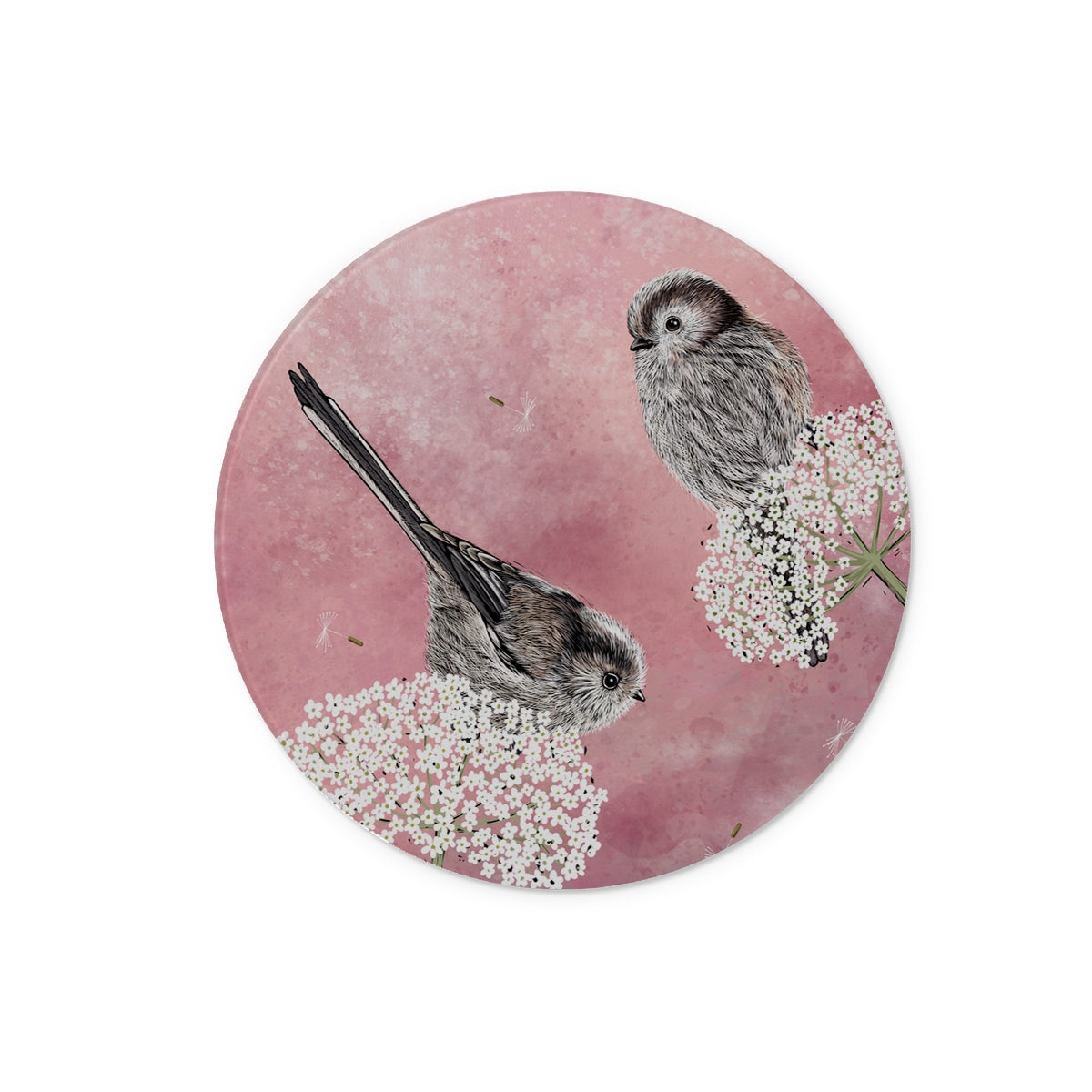 This circular long tailed tits tempered glass chopping board design from Fox and Boo depicts two cute long tailed tits balancing on some cow parsley, background is a watercolour berry pink, with floating dandelion puffs.