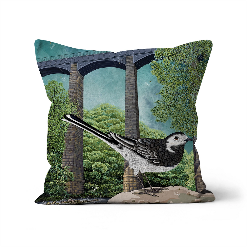 A square decorative throw pillow featuring a detailed illustration of a black-and-white wagtail perched in front of the stone pontcysyllte aqueduct and world heritage site, nd green trees, shown on a clean white background.