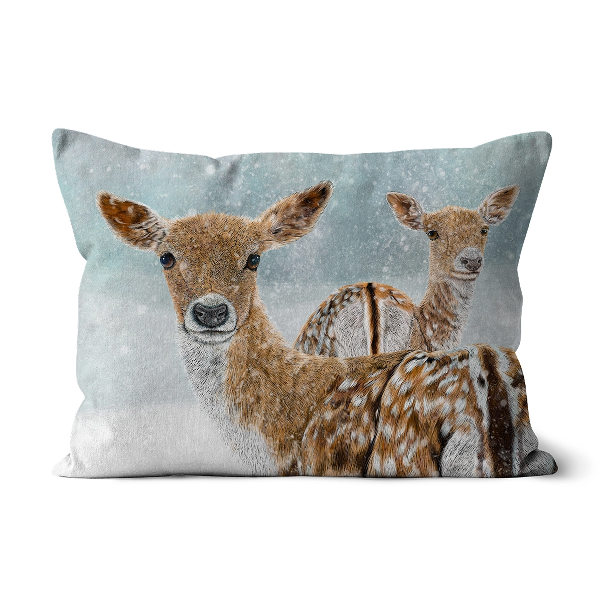 A rectangular decorative pillow or cushion featuring a printed winter scene of two brown deer with white spots against a snowy light blue-gray background, shown on a plain white studio background.
