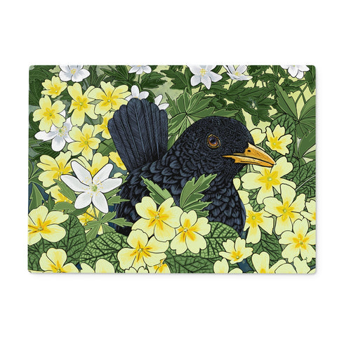 Blackbird and Primrose Glass Worktop Saver, cute blackbird is partially hidden in this design, it is peeping out from behind dozens of yellow primroses and wood sorrel.